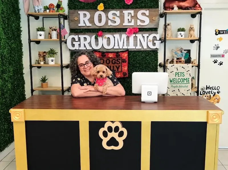 Groomer sosteniendo un perrito en la recepción de Rose’s Grooming House en Miami Springs